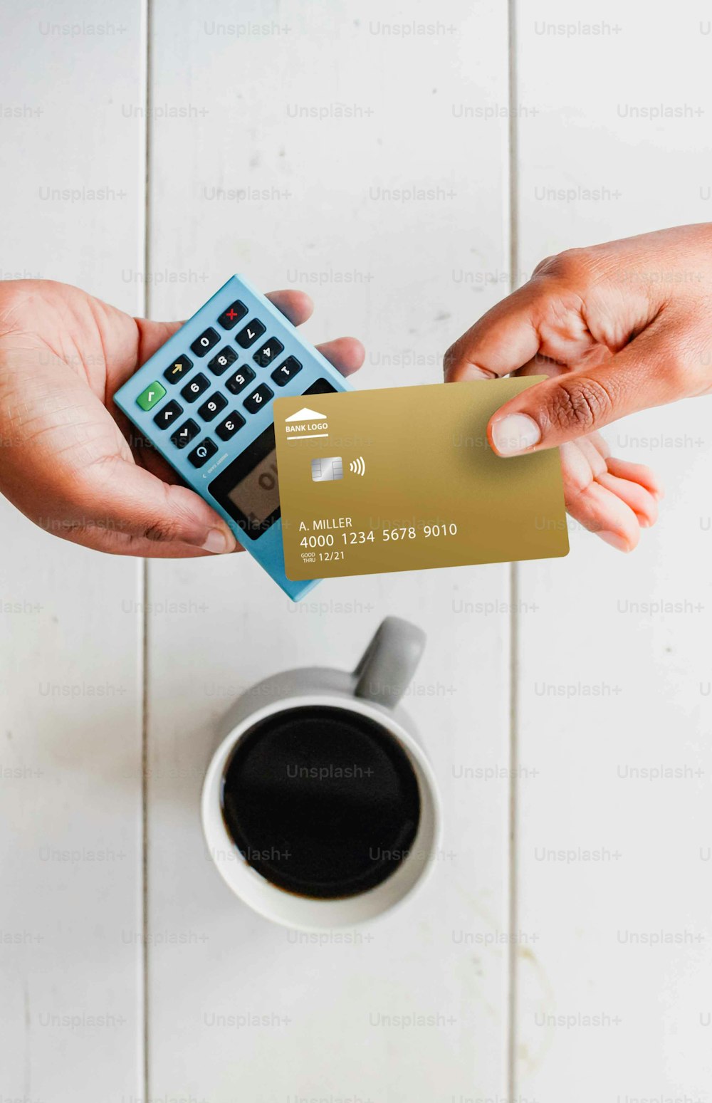 duas mãos segurando um cartão de crédito e uma calculadora