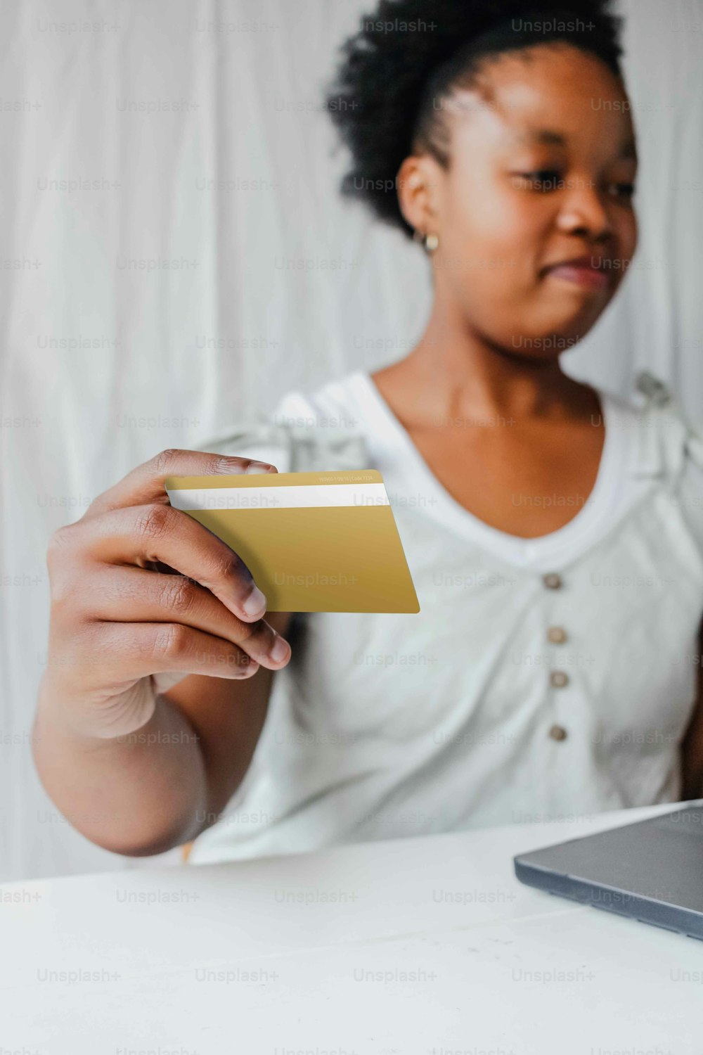 a woman sitting at a table holding a credit card