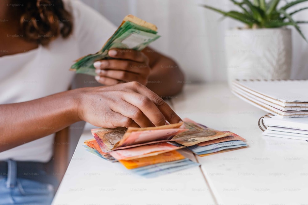 a person sitting at a table with stacks of money