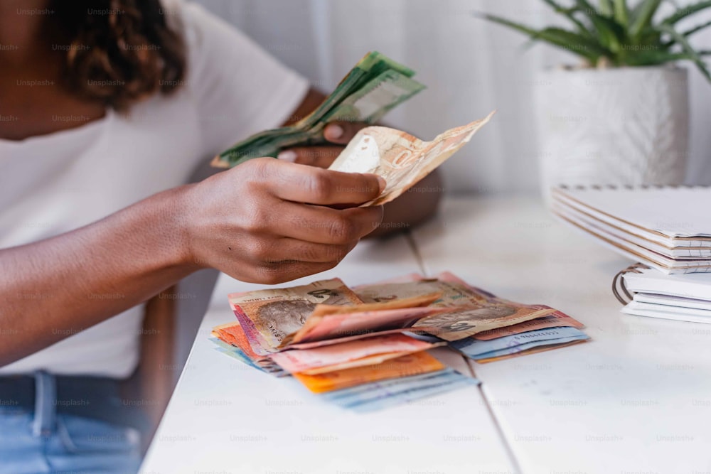 a person sitting at a table with stacks of money