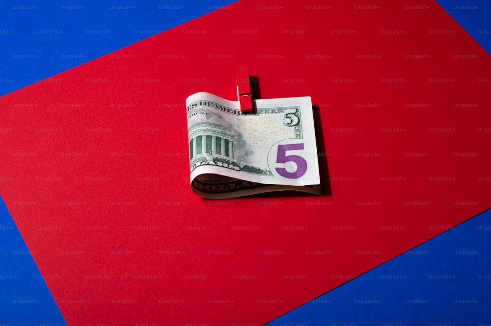 a red and blue background with a note with the number five on it
