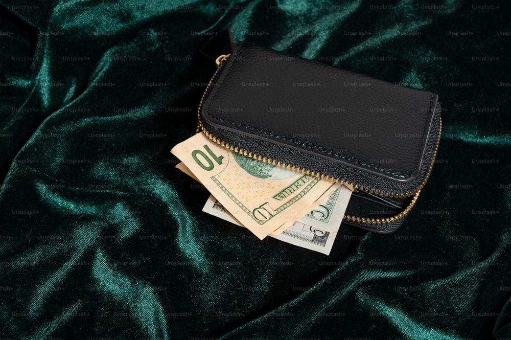 a black purse with money sticking out of it