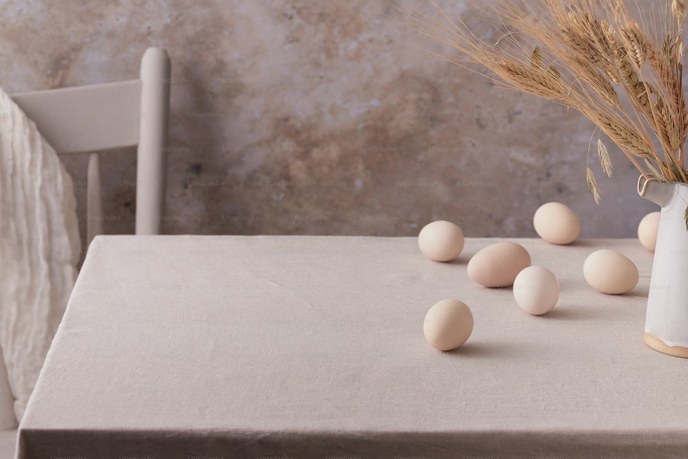테이블 위에 앉아있는 계란으로 가득 찬 흰색 꽃병