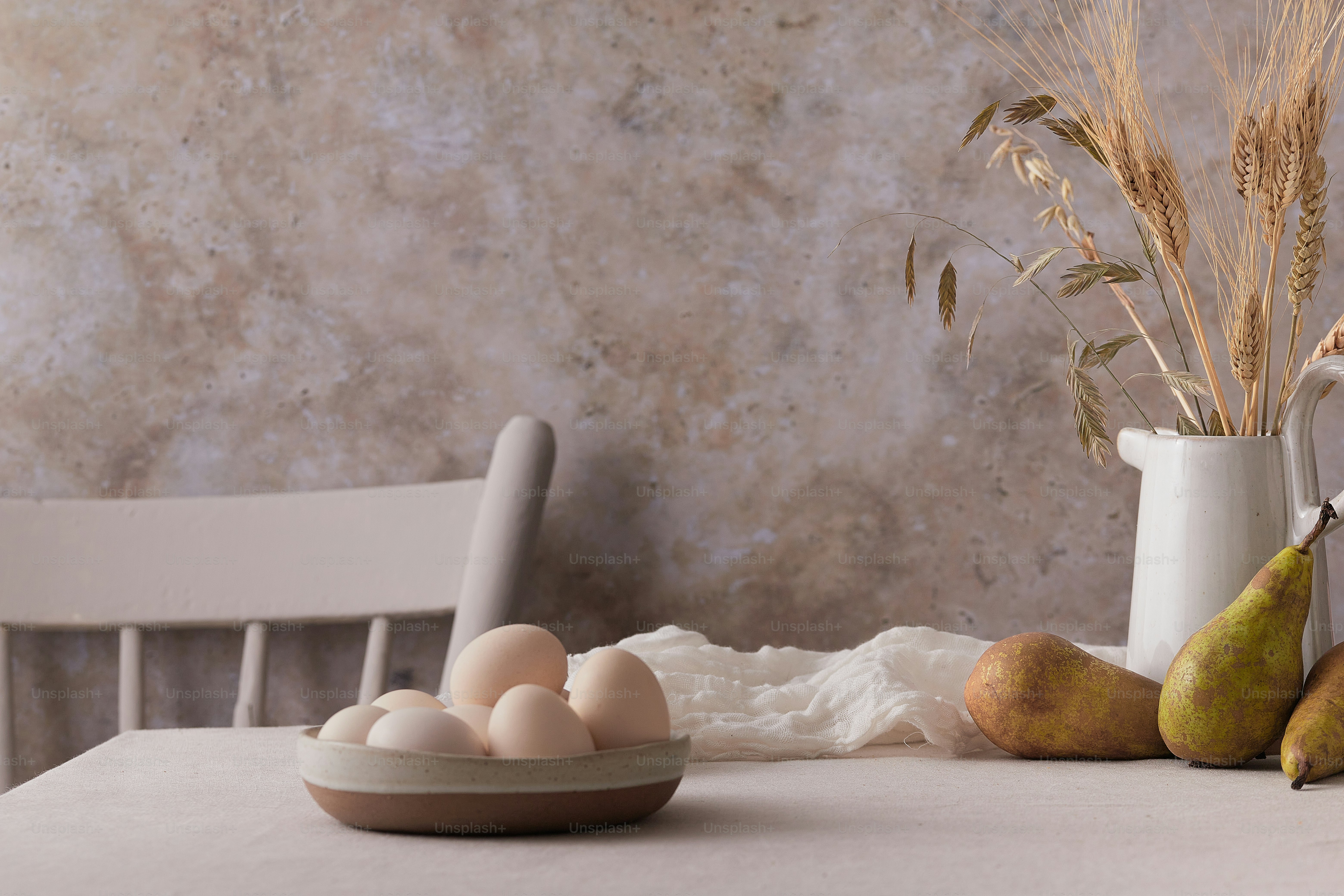 a table topped with a bowl of eggs and pears
