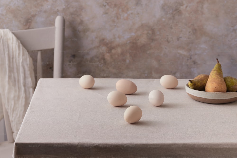 a bowl of eggs and some pears on a table