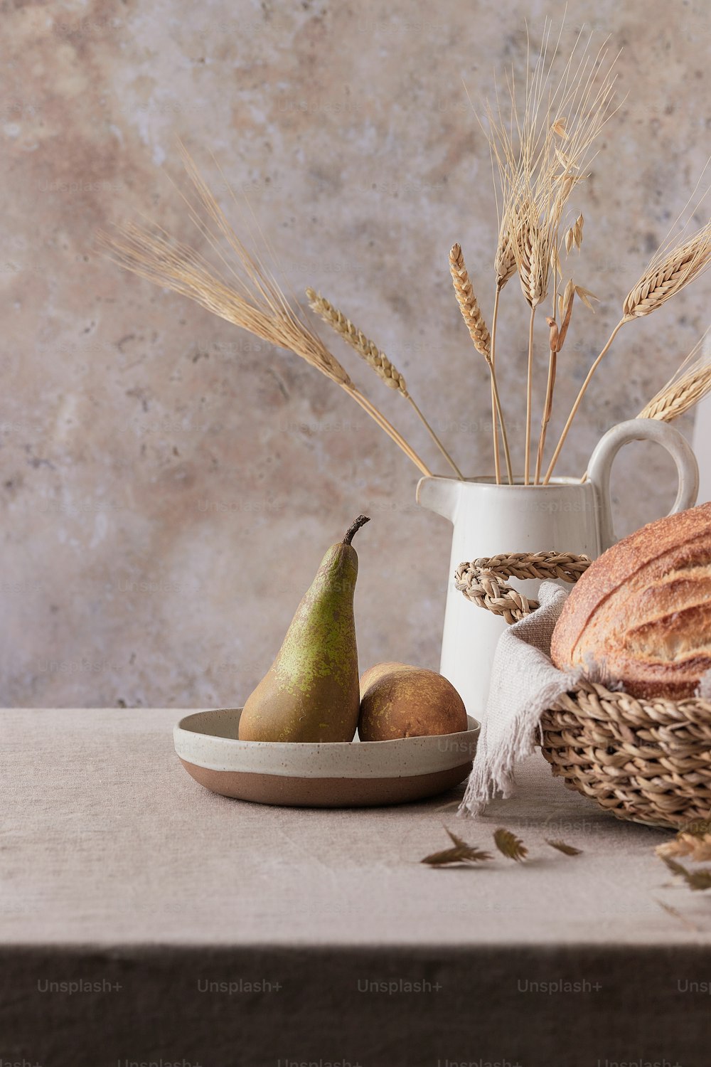 a table topped with a bowl of bread and a pear