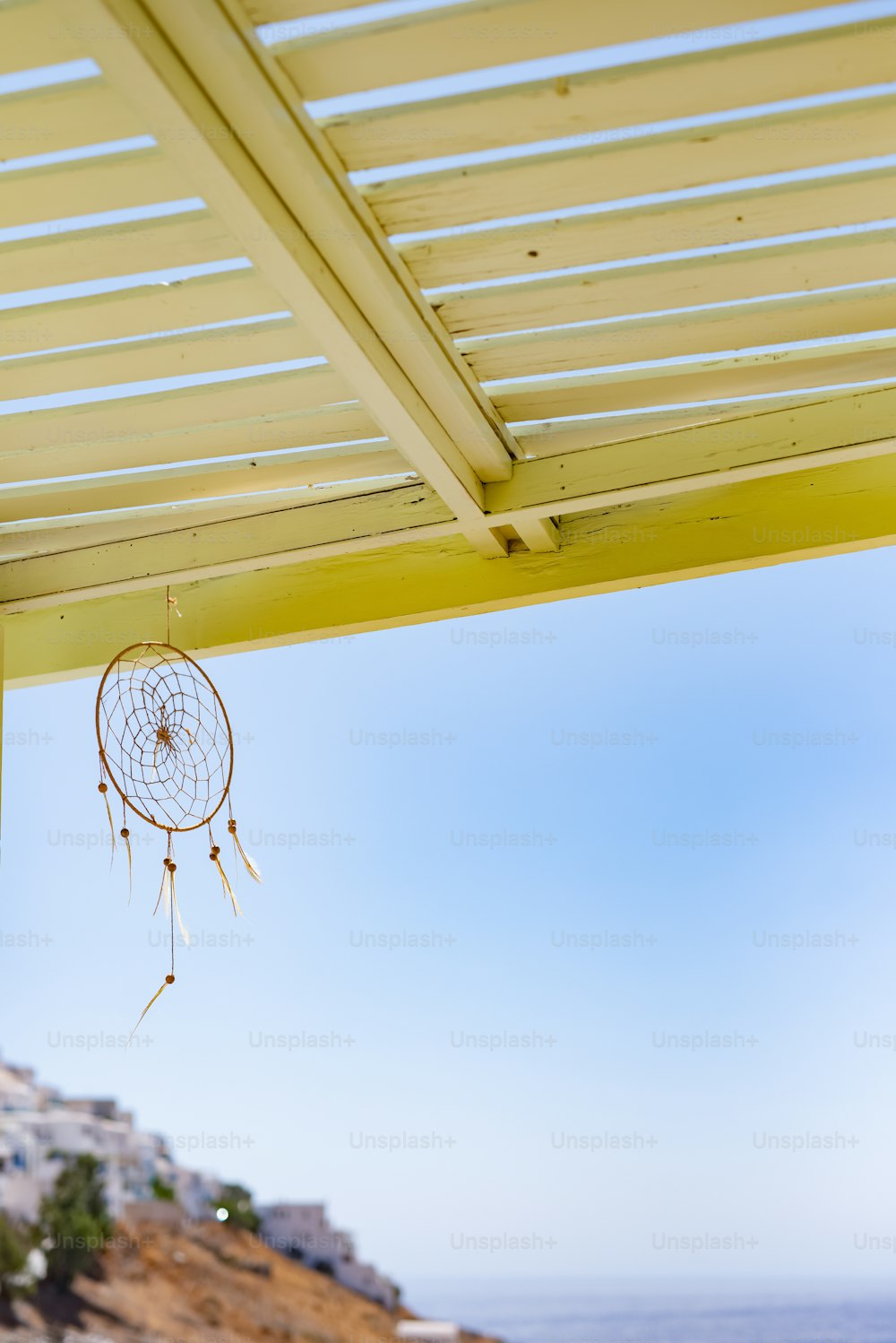 a dream catcher hanging from a yellow roof