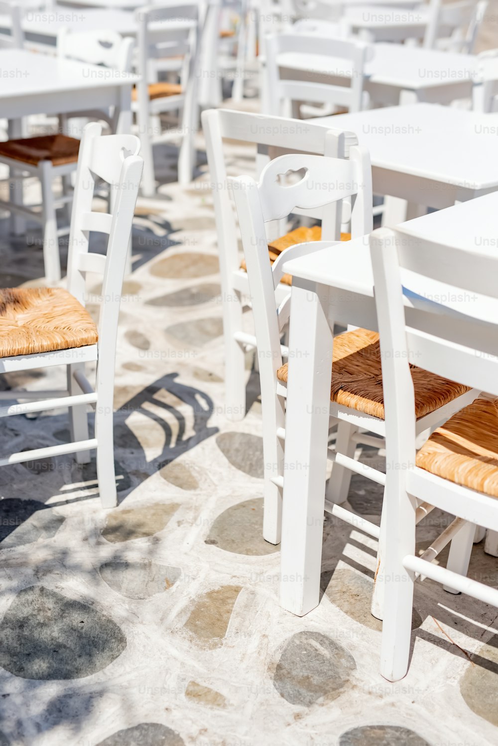 a number of white tables and chairs near one another