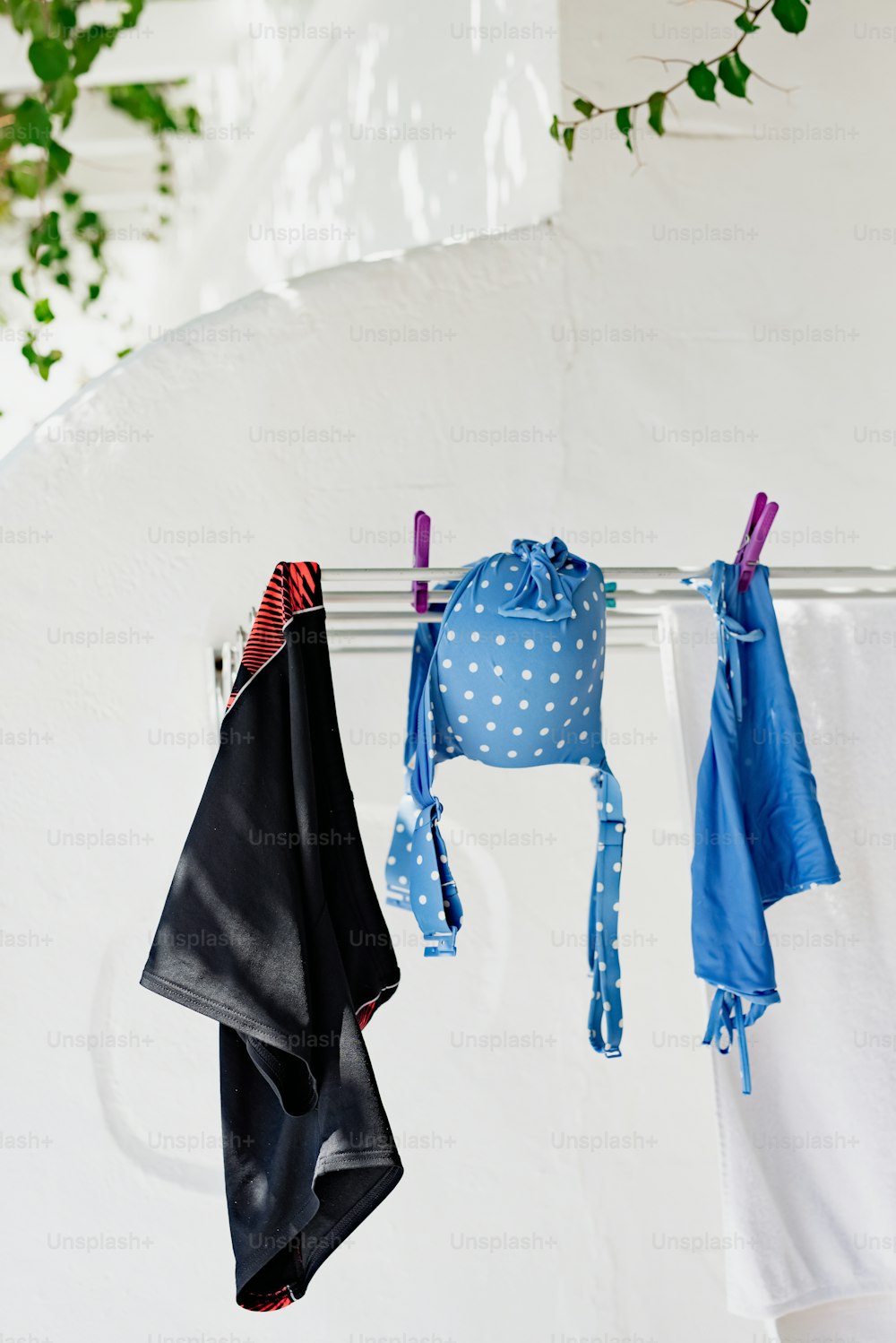 clothes hanging on a clothes line next to a white wall