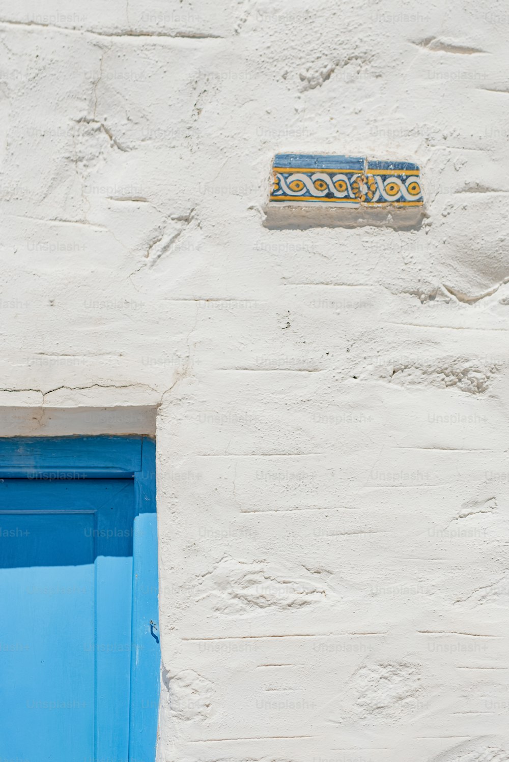 um edifício azul e branco com uma porta azul