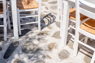 a group of white chairs sitting on top of a stone floor