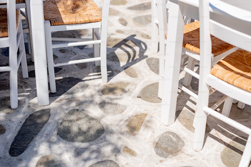 a group of white chairs sitting on top of a stone floor