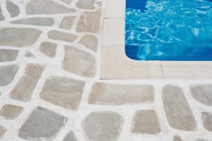 ein Pool mit einem Steinboden daneben