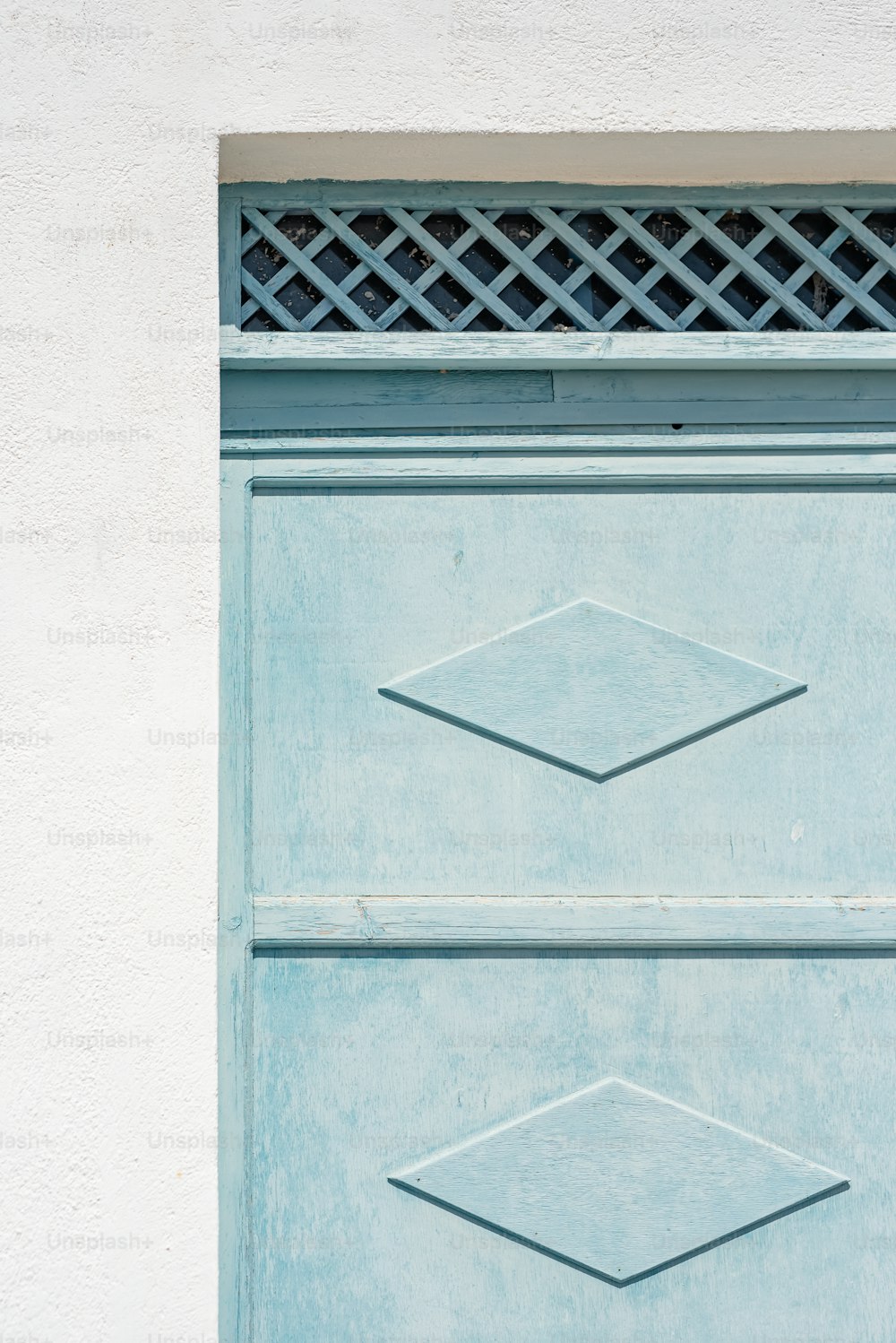 Un primer plano de una puerta azul con una rejilla de metal
