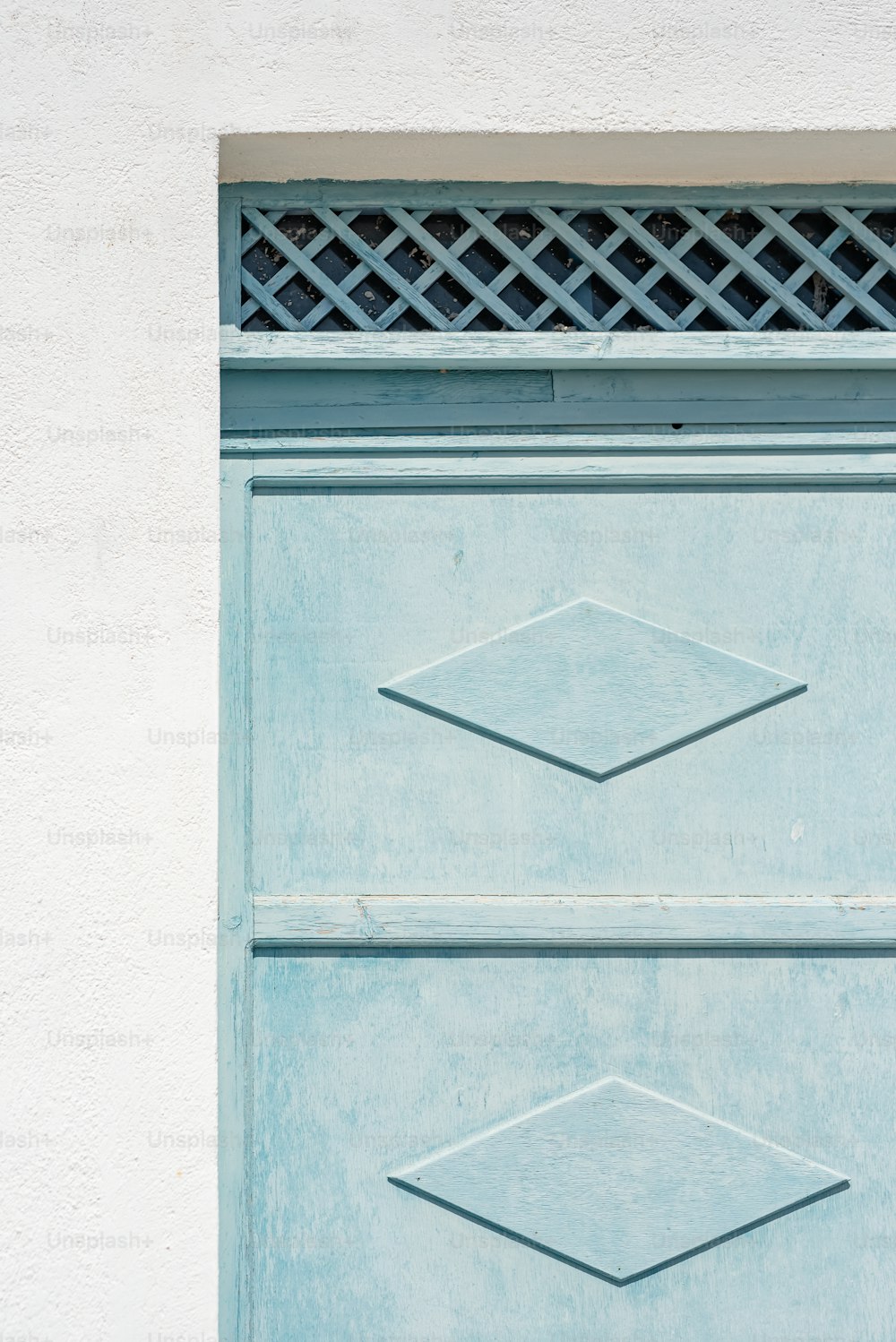 a close up of a blue door with a metal grate