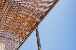 Un primo piano di un tetto di bambù con un cielo blu sullo sfondo
