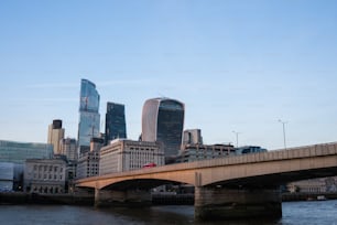 a bridge over a river with a city in the background