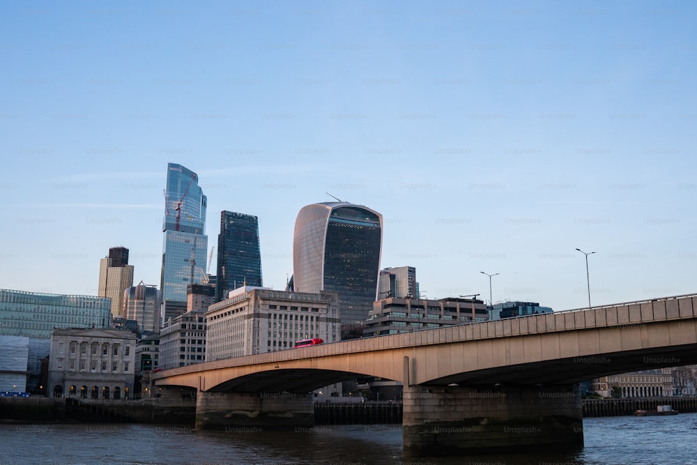 a bridge over a river with a city in the background