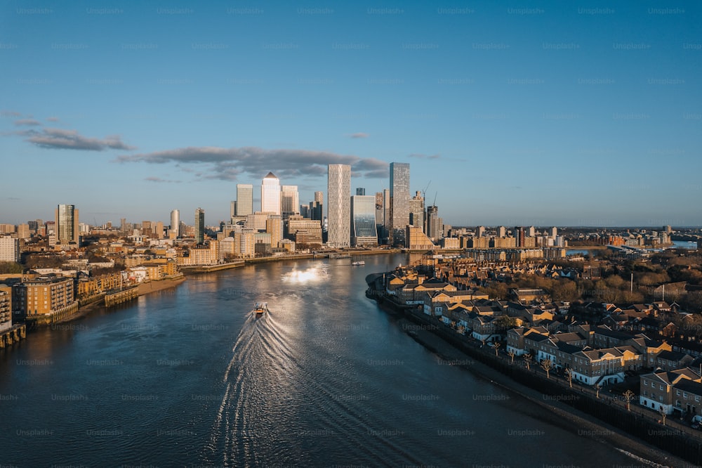 a boat traveling down a river next to a city