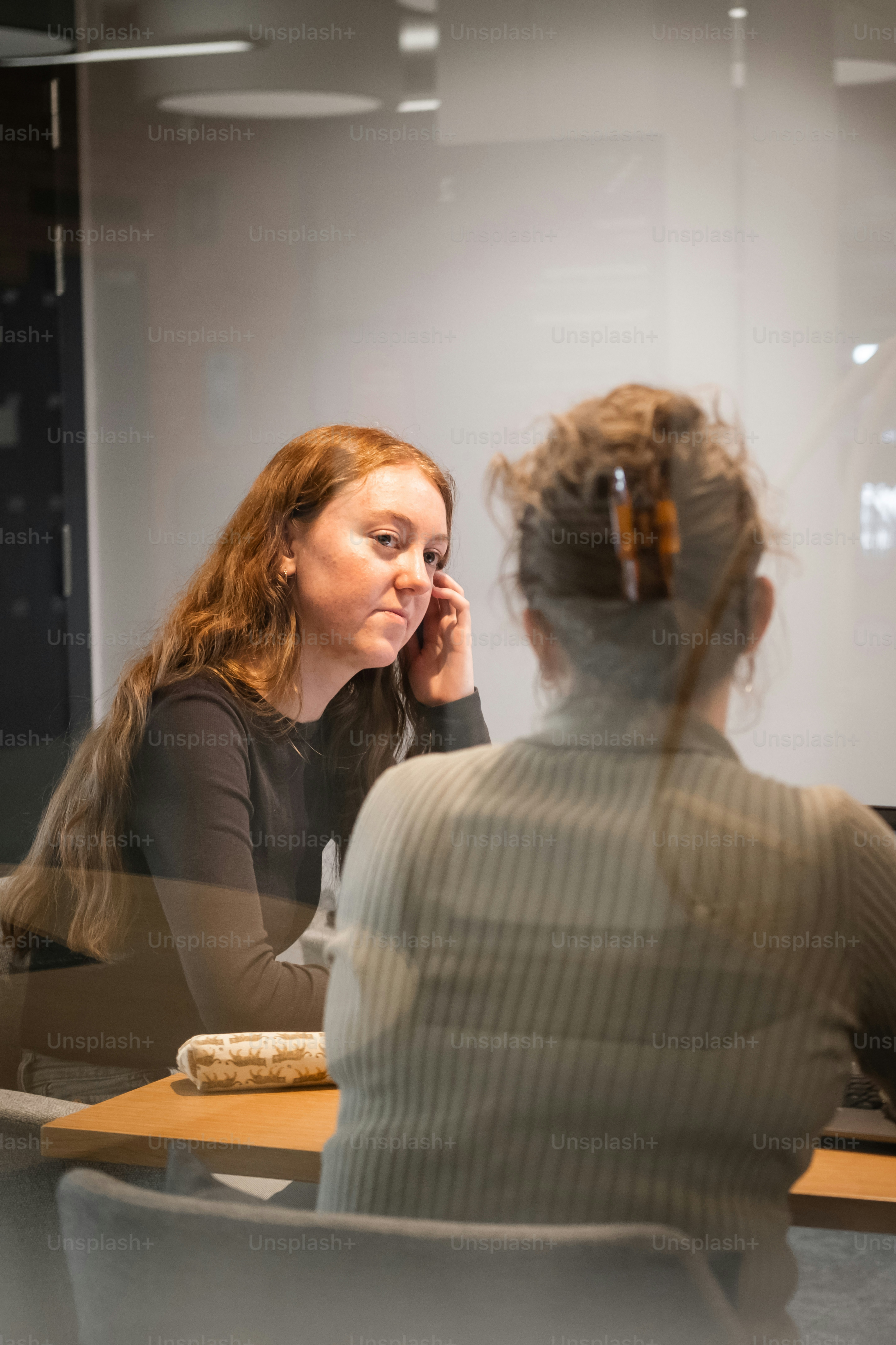 una donna seduta a un tavolo che parla al cellulare