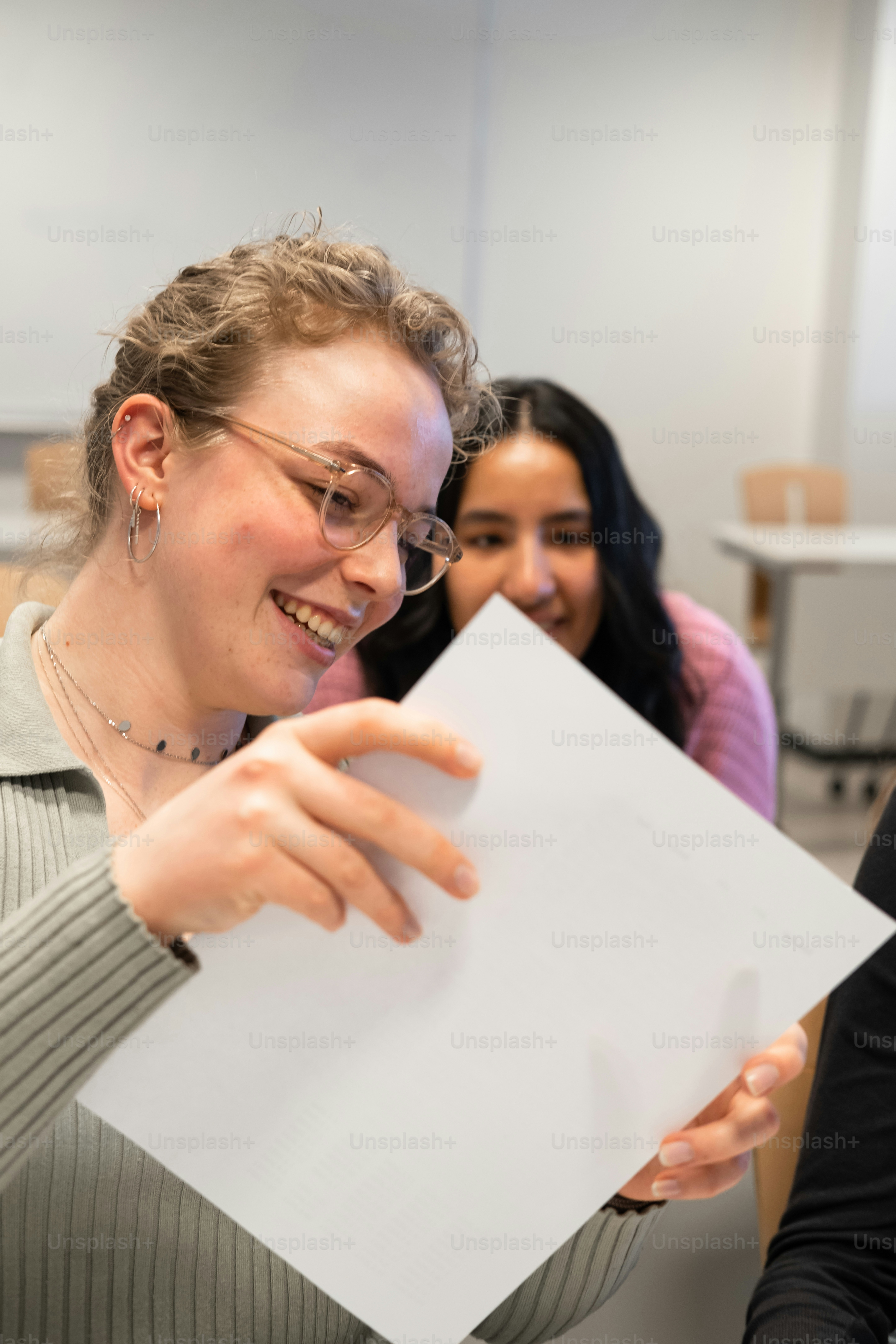 a woman holding a piece of paper in front of her face