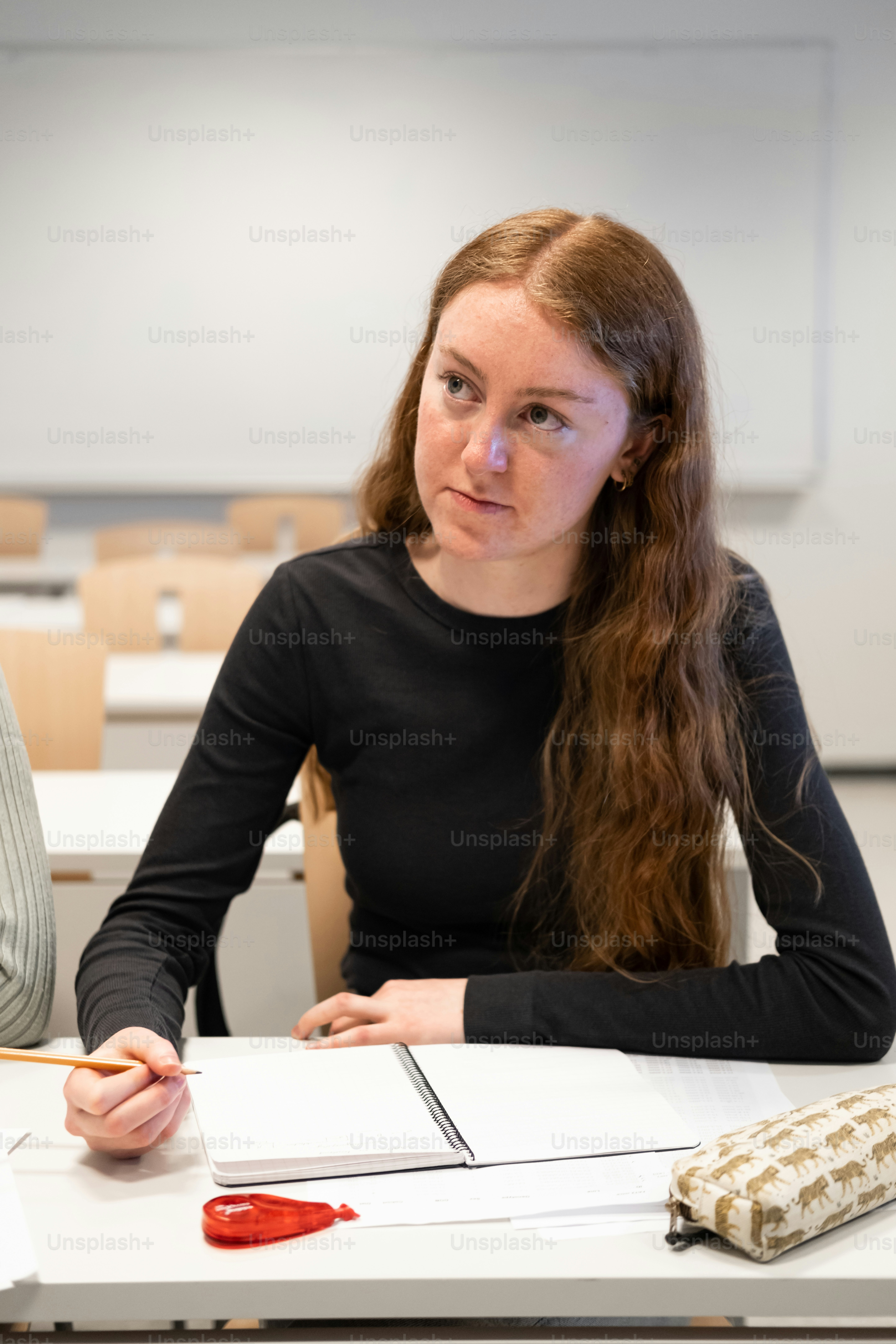 a woman sitting at a table in front of a book