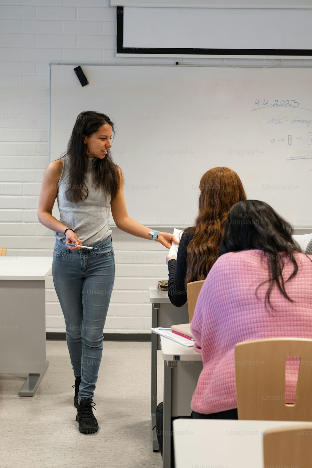 a woman standing in front of a class room