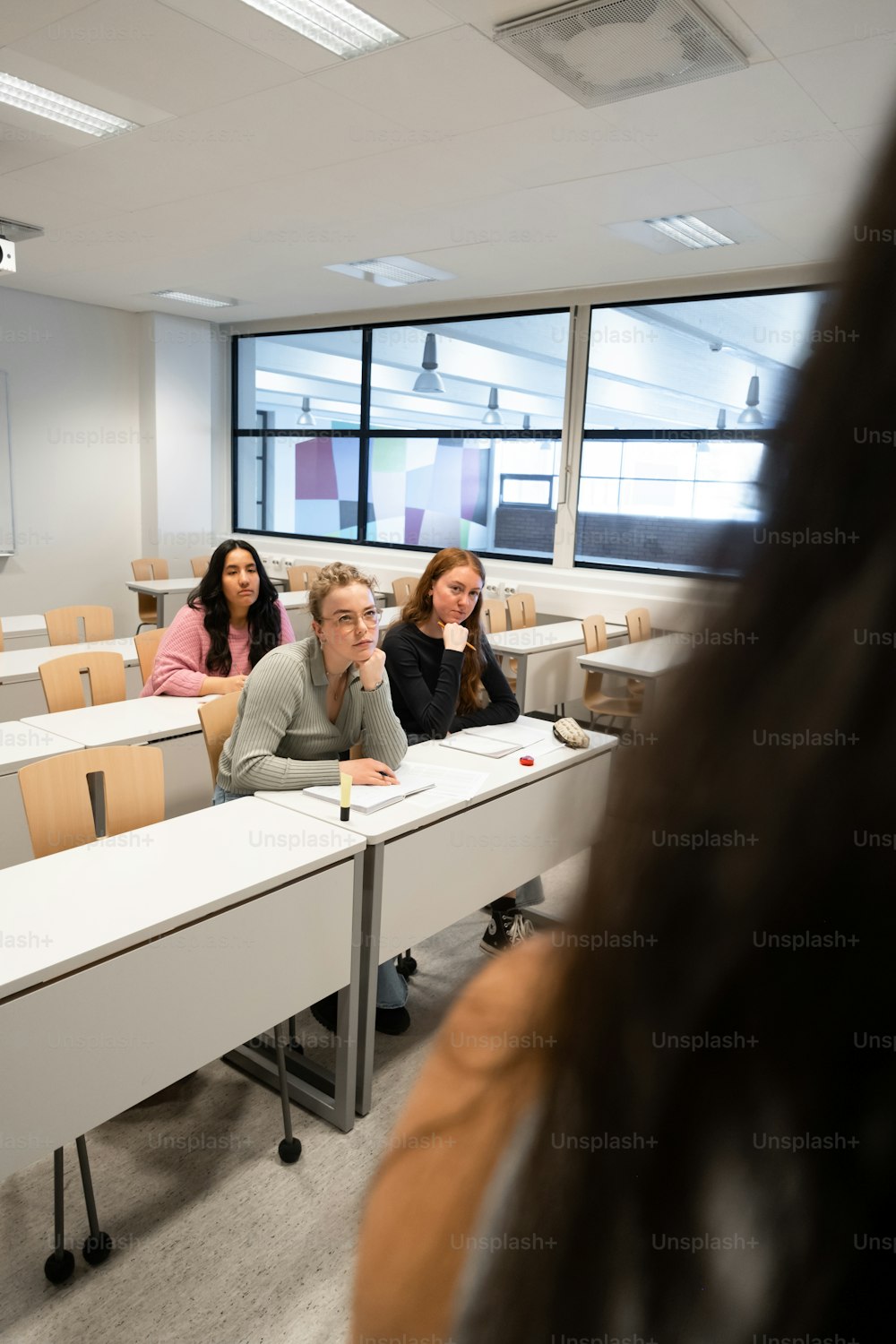 un gruppo di persone sedute ai banchi in un'aula