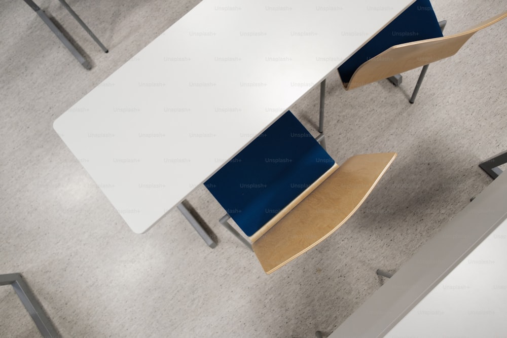 a white table with a blue chair next to it