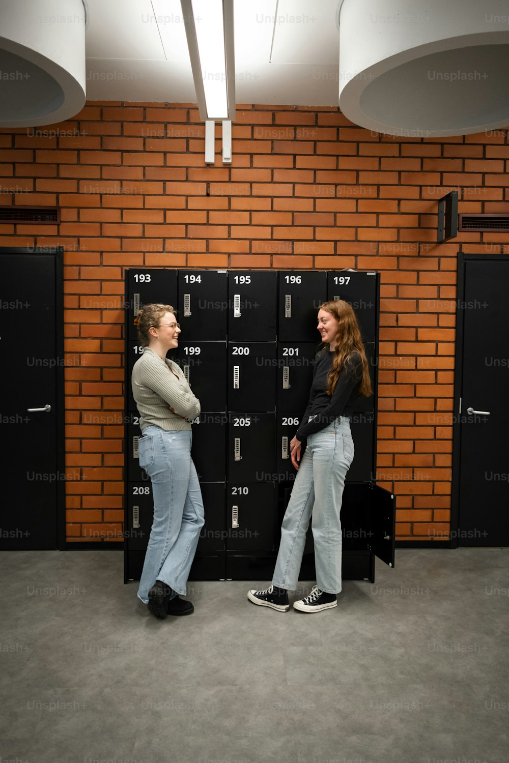 a couple of people standing in front of lockers