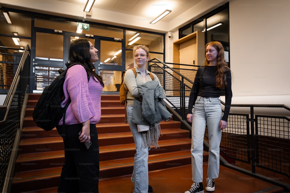 a group of women standing on a staircase talking to each other