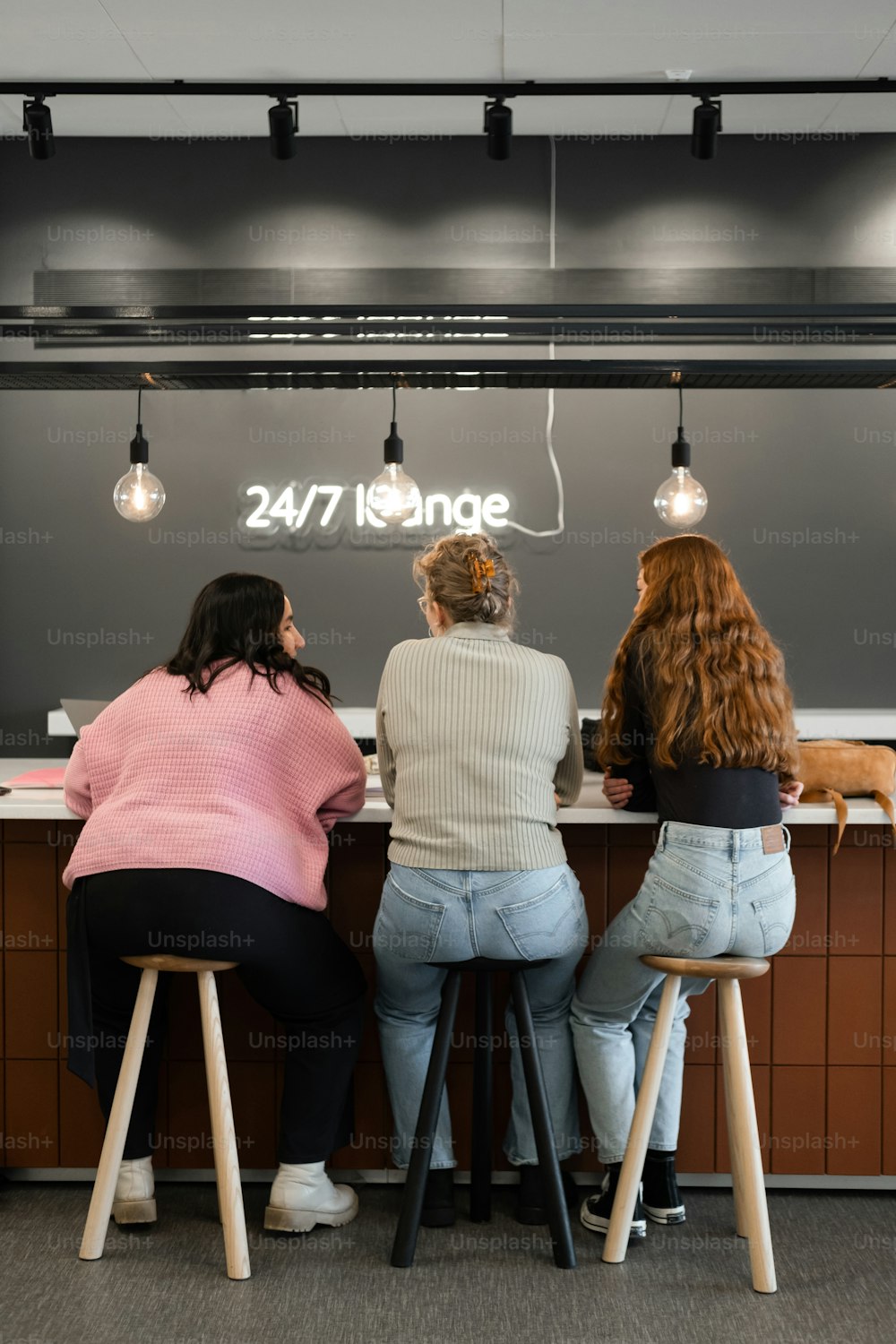 three women sitting at a counter in a restaurant
