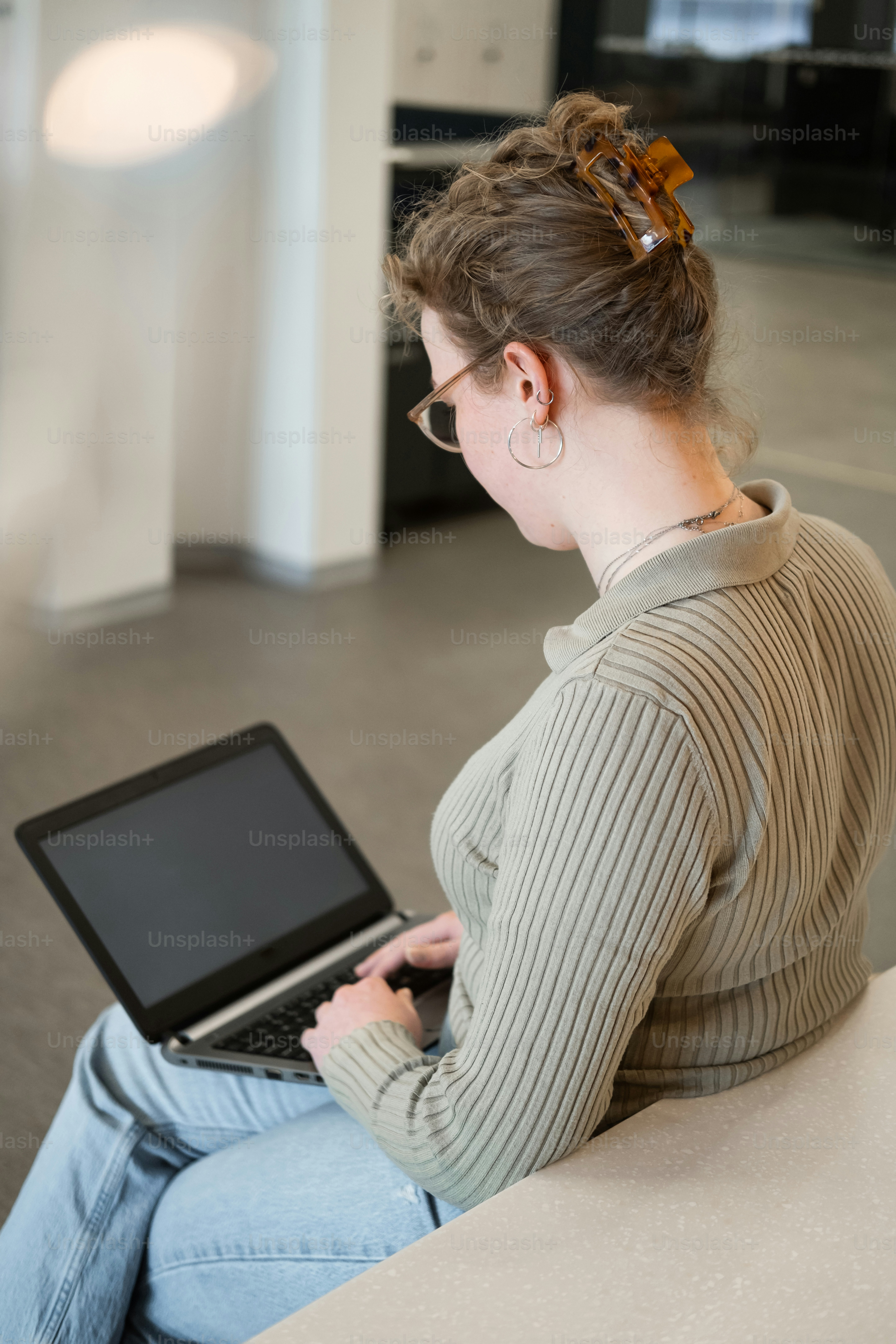 a woman sitting on a couch using a laptop computer