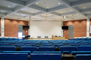 Un gran auditorio con filas de sillas azules