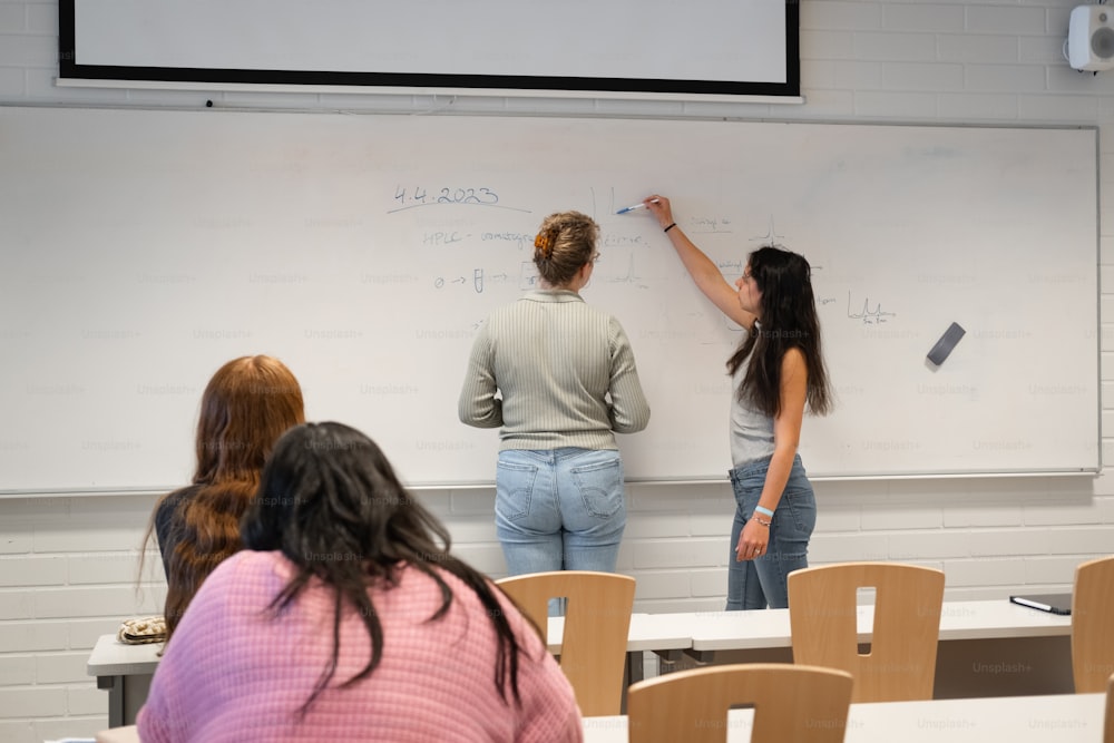 a group of people writing on a white board