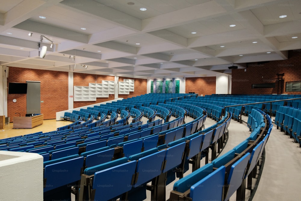 um grande auditório com fileiras de cadeiras azuis