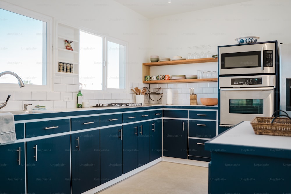 una cucina con armadi blu e un forno a microonde