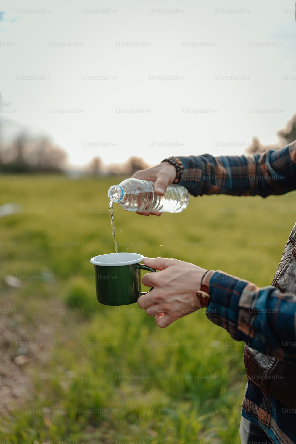 a person pouring water into a green cup