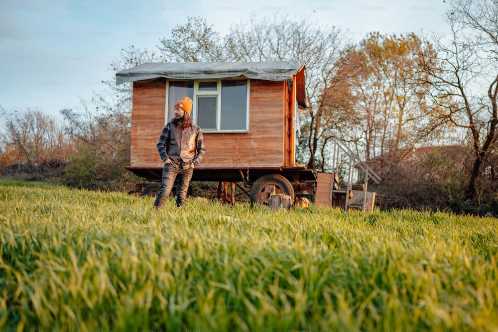 a person standing in front of a small wooden cabin