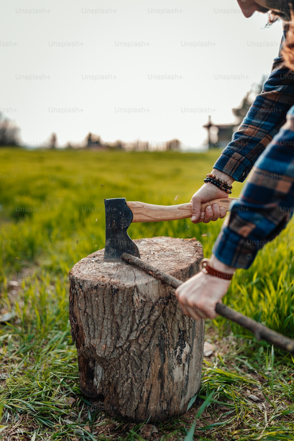 a woman is holding a hammer over a tree stump
