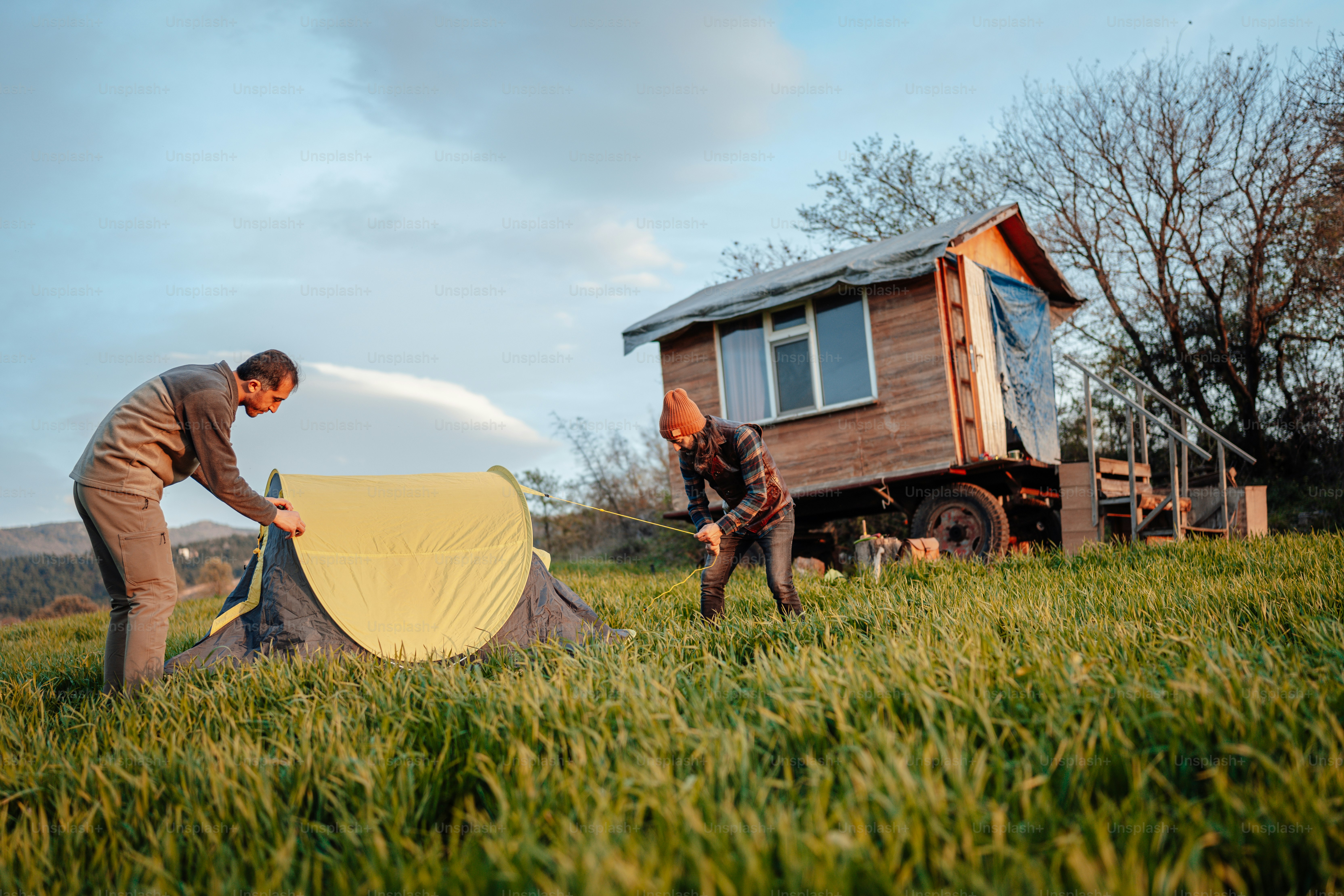 a couple of men standing next to a tent