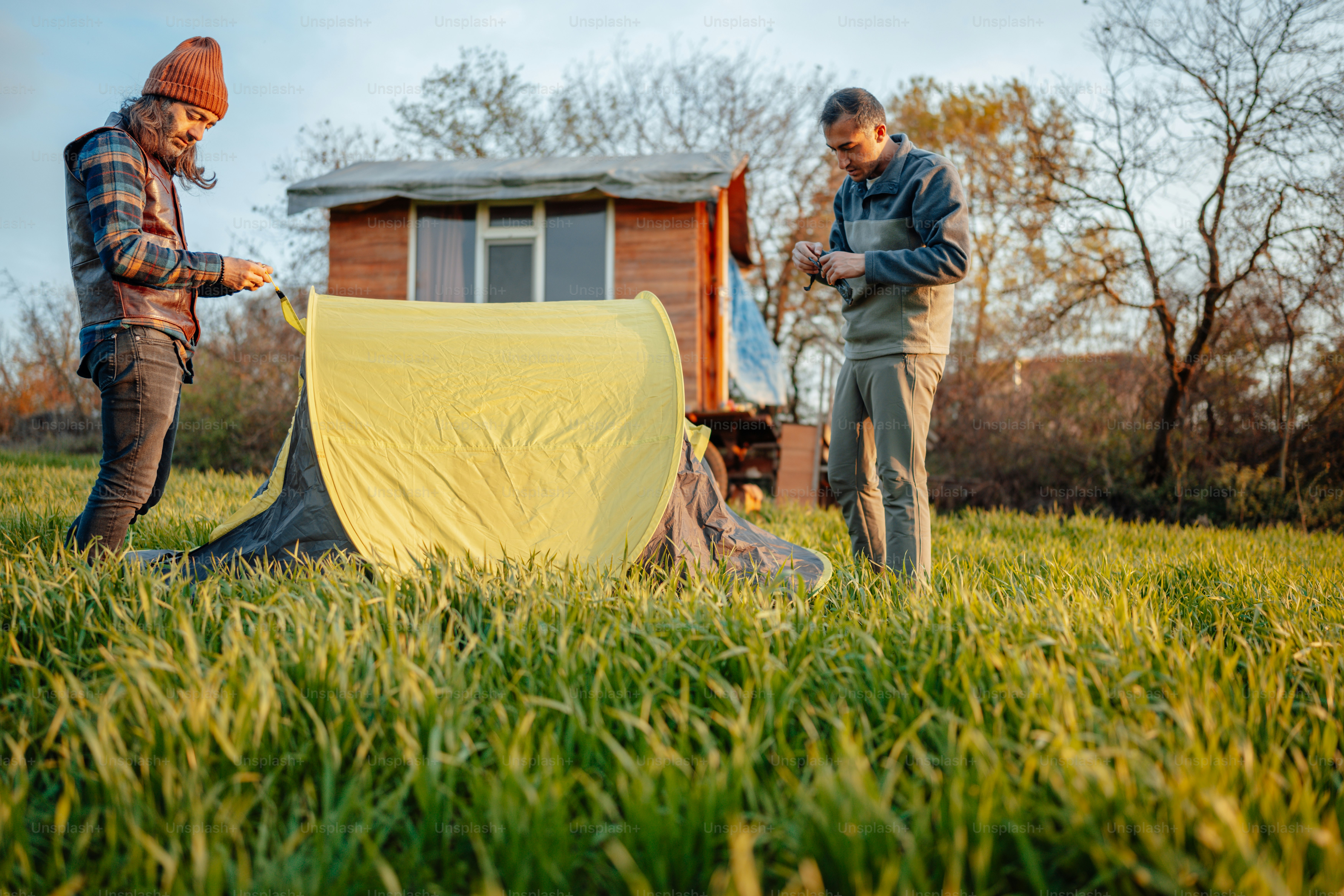 a couple of men standing next to a tent