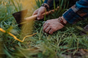 une personne avec une pioche dans l’herbe