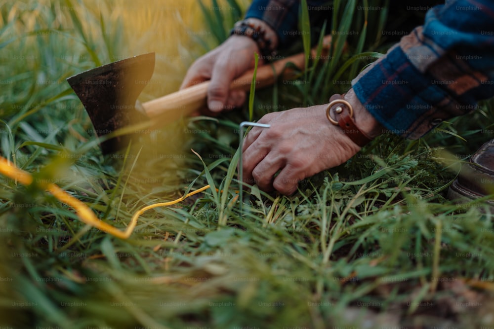 a person with a pick axe in the grass