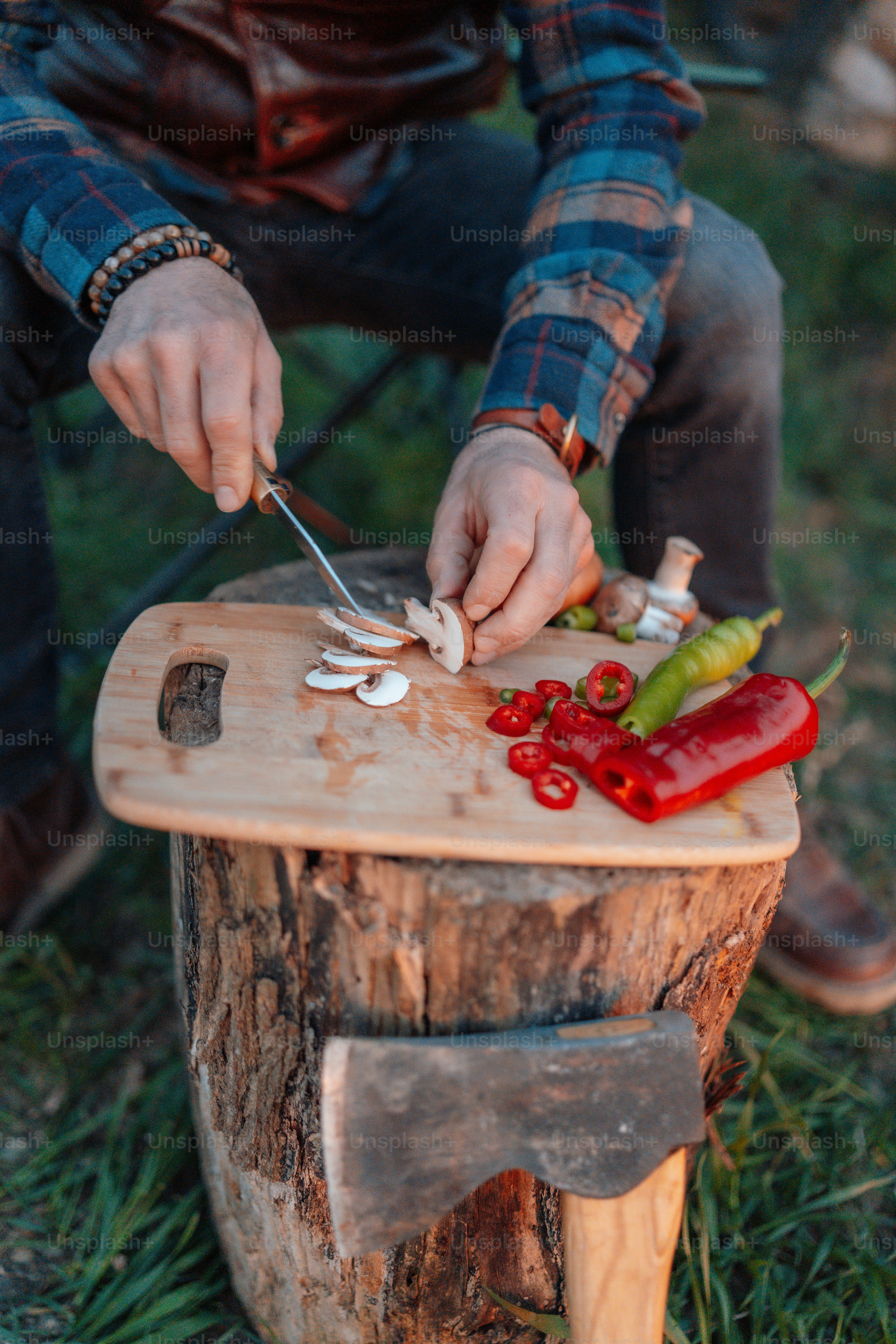 a person cutting mushrooms on a wooden board