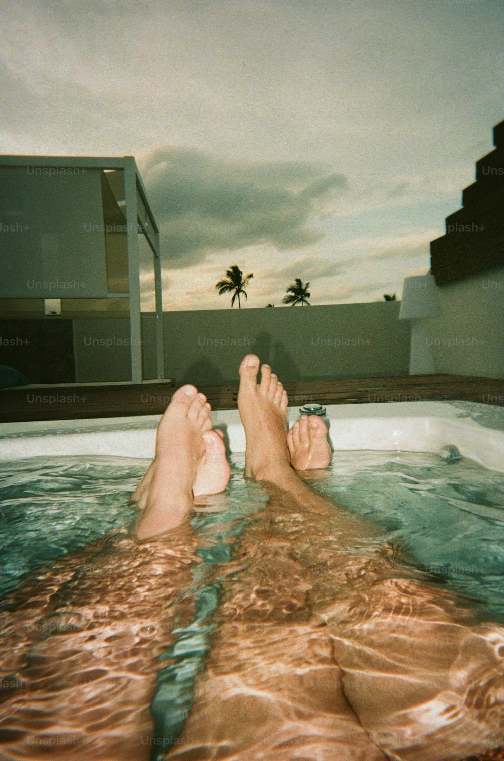 a person laying in a hot tub with their feet in the water
