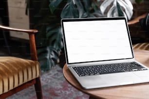 un ordinateur portable posé sur une table en bois