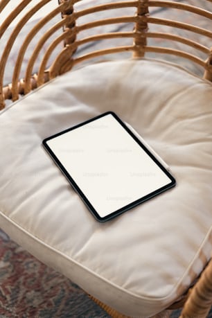 a tablet sitting on top of a cushion on a chair