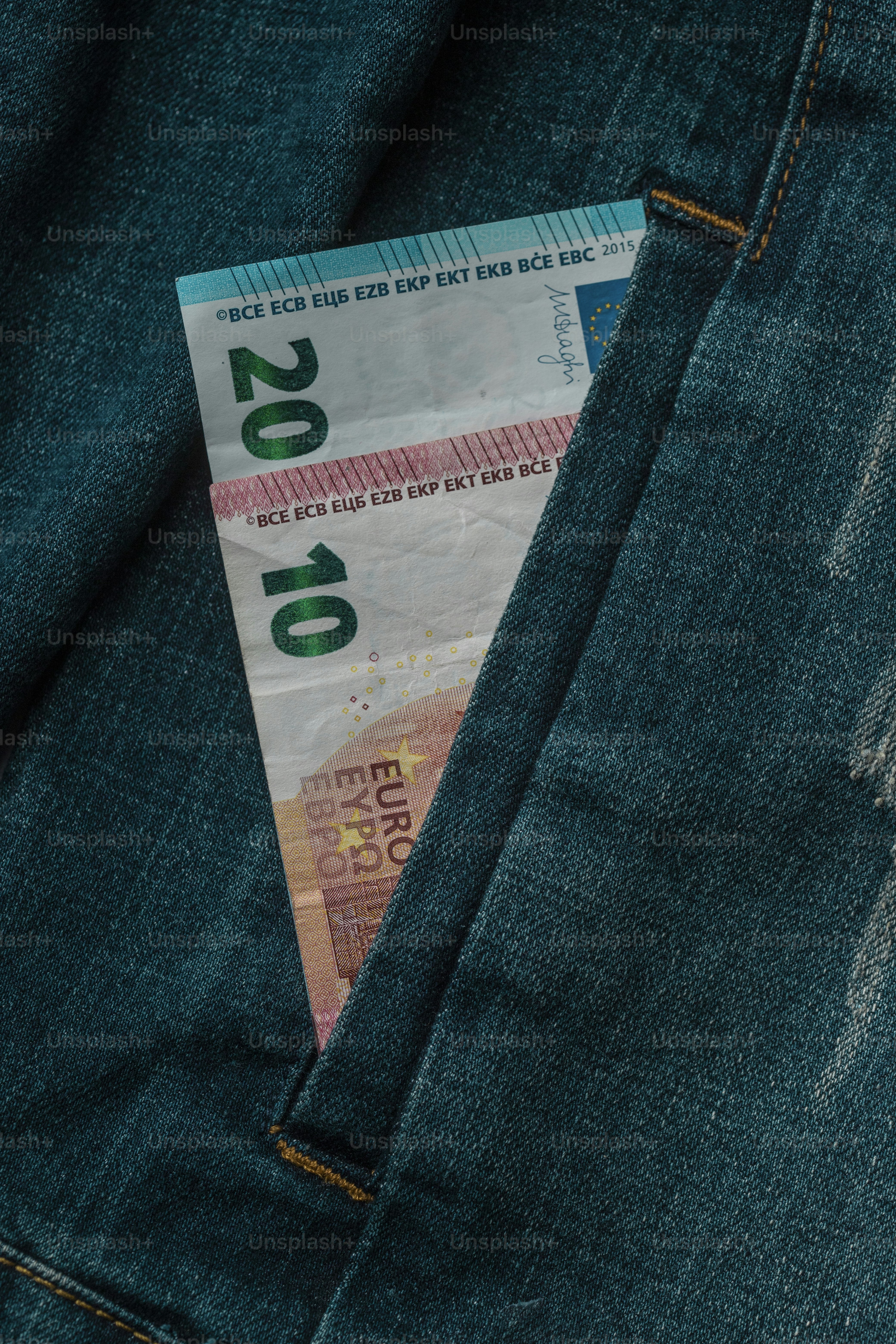 a money bill sticking out of the back pocket of a pair of jeans