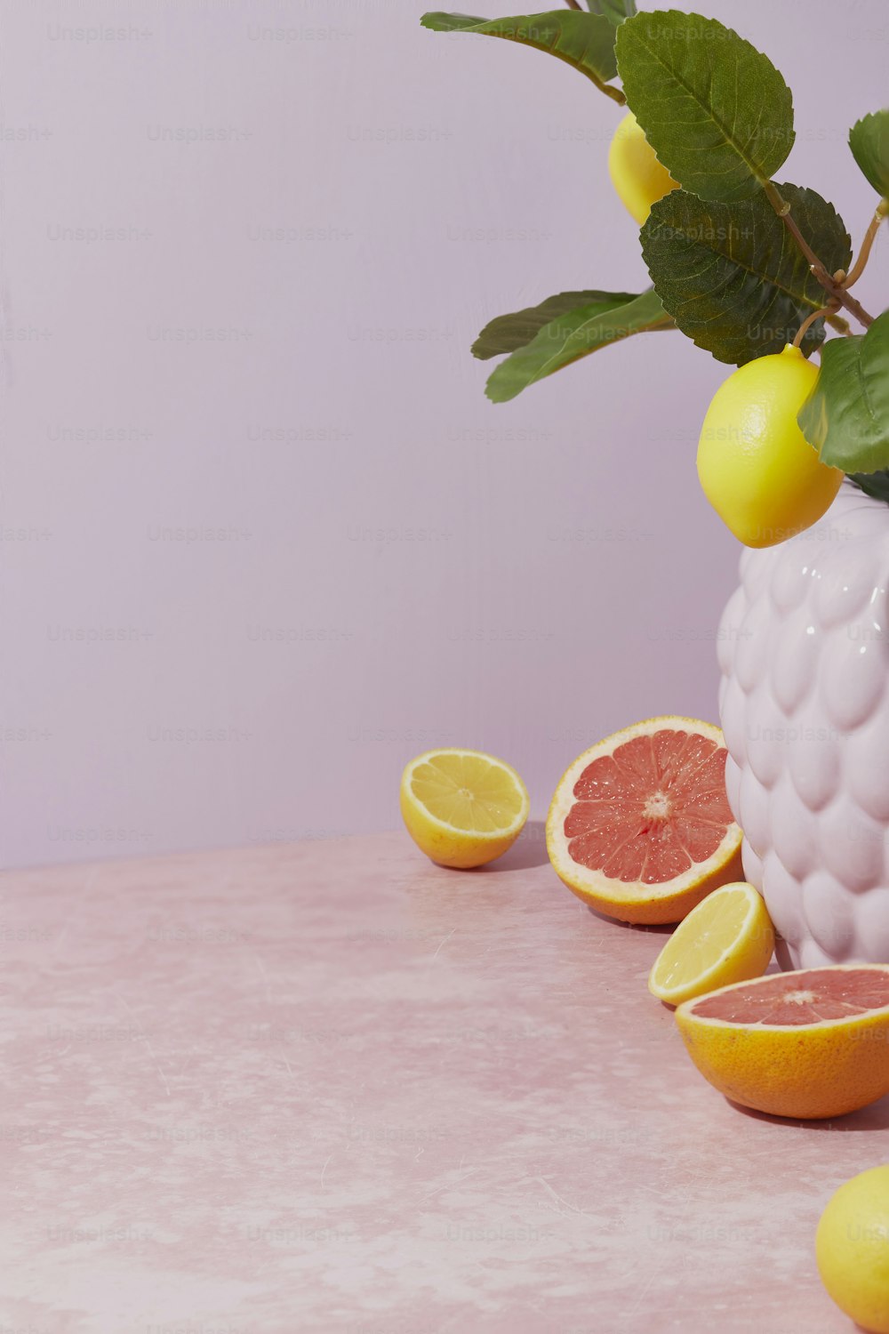 グレープフルーツとレモンでいっぱいの白い花瓶